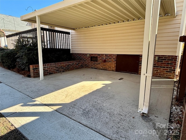 view of patio with an attached carport and driveway