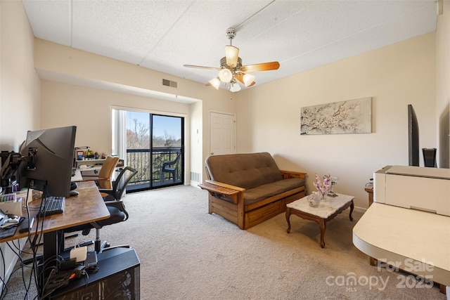 office area featuring a ceiling fan, visible vents, and carpet flooring