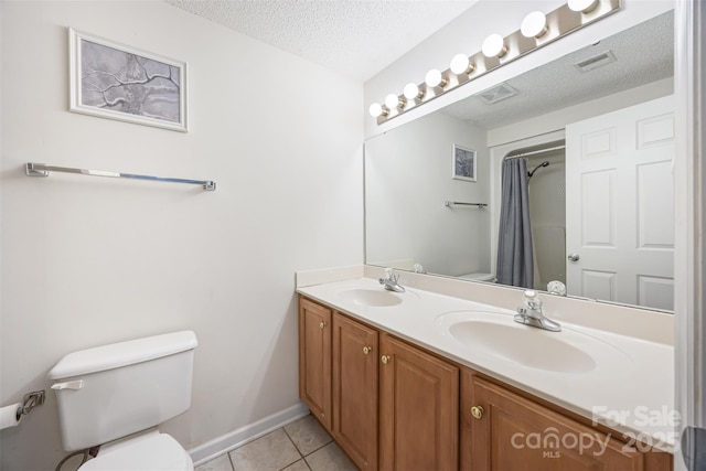 bathroom featuring tile patterned flooring, a sink, a textured ceiling, and toilet