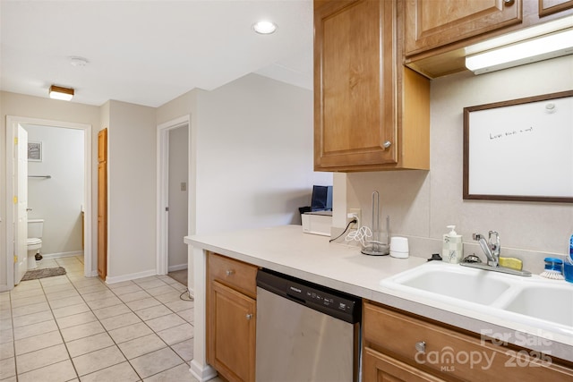 kitchen featuring light tile patterned floors, brown cabinetry, dishwasher, light countertops, and a sink