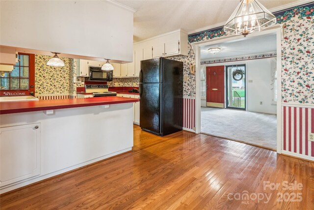 1007 Wentworth Dr, Kannapolis, NC 28081 - kitchen featuring wallpapered walls, an inviting chandelier, ornamental molding, light wood-style flooring, and black appliances