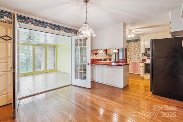 1007 Wentworth Dr, Kannapolis, NC 28081 - kitchen with freestanding refrigerator, light wood-style floors, electric stove, a peninsula, and ceiling fan with notable chandelier