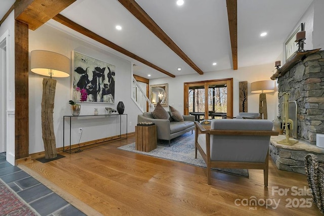 living area with recessed lighting, a fireplace, wood finished floors, stairs, and beam ceiling