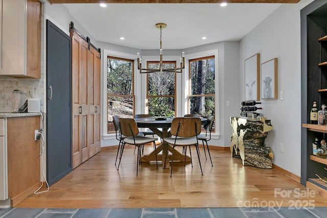 dining area featuring baseboards, a barn door, light wood-style flooring, and recessed lighting