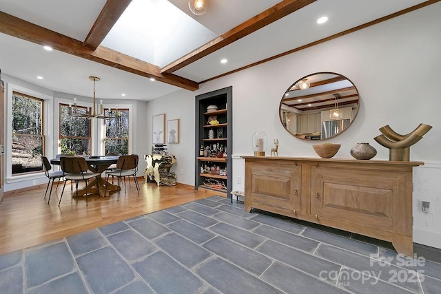 dining room featuring built in shelves, recessed lighting, a skylight, wood finished floors, and beam ceiling