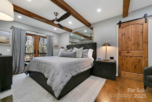 bedroom with beam ceiling, french doors, a barn door, wood finished floors, and access to outside