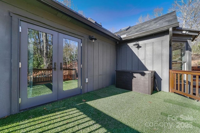 view of property exterior with french doors and a lawn