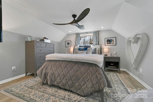 bedroom with lofted ceiling, light wood-style flooring, and baseboards