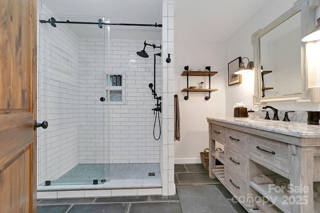 bathroom with a shower stall, vanity, and baseboards