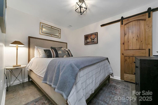 bedroom featuring a barn door, visible vents, and baseboards