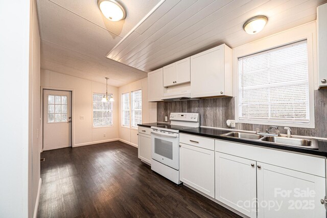 kitchen with electric range, dark countertops, hanging light fixtures, white cabinetry, and a sink