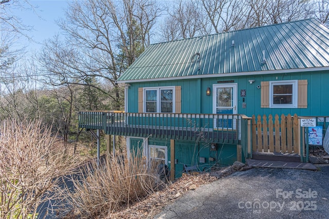 view of front of home featuring metal roof and a wooden deck