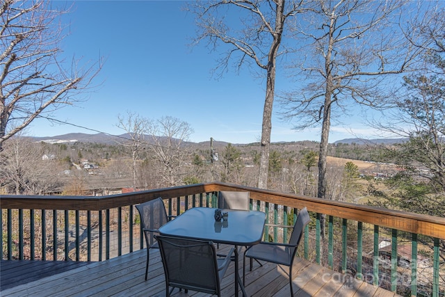 deck featuring outdoor dining area and a mountain view