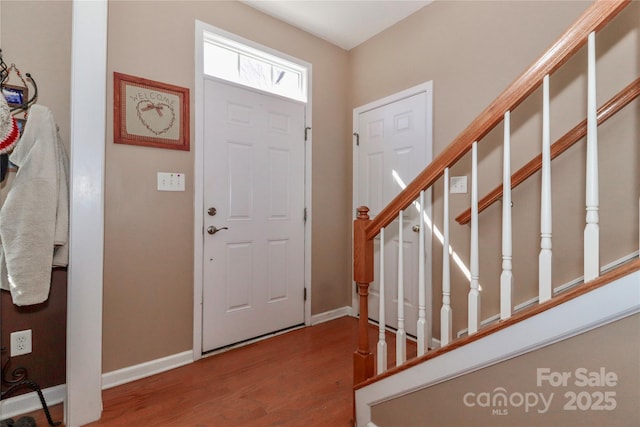 foyer featuring stairs, wood finished floors, and baseboards