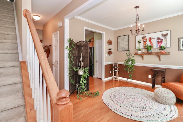 entrance foyer with baseboards, stairway, wood finished floors, and ornamental molding