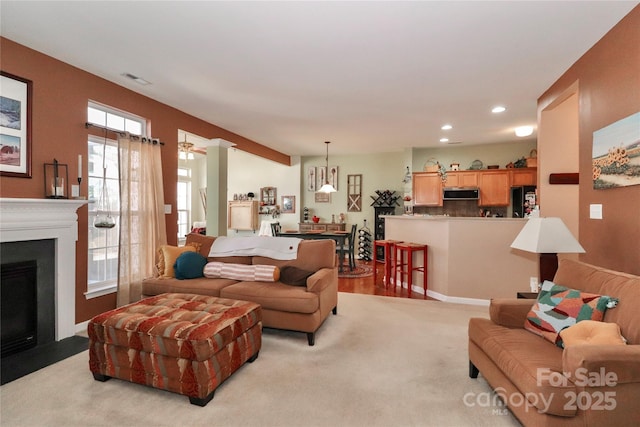 carpeted living room featuring a fireplace with flush hearth and recessed lighting