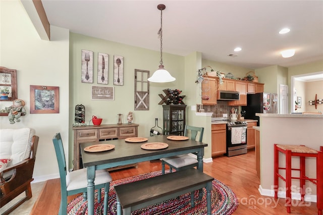 dining area with light wood-type flooring, visible vents, baseboards, and recessed lighting