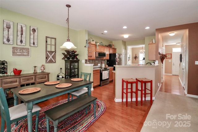 dining space with baseboards, recessed lighting, and light wood-style floors