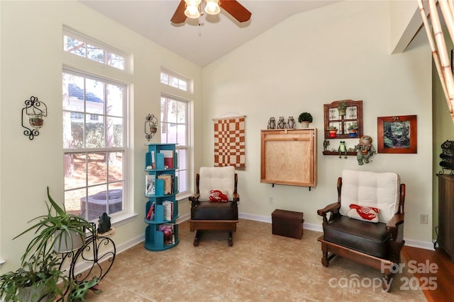 sitting room featuring light tile patterned floors, baseboards, vaulted ceiling, and a ceiling fan