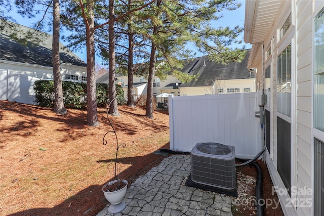 view of yard featuring fence, central AC unit, and a patio