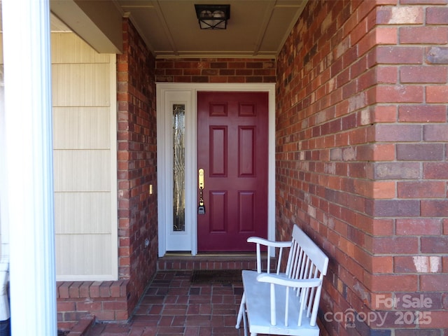 doorway to property with brick siding