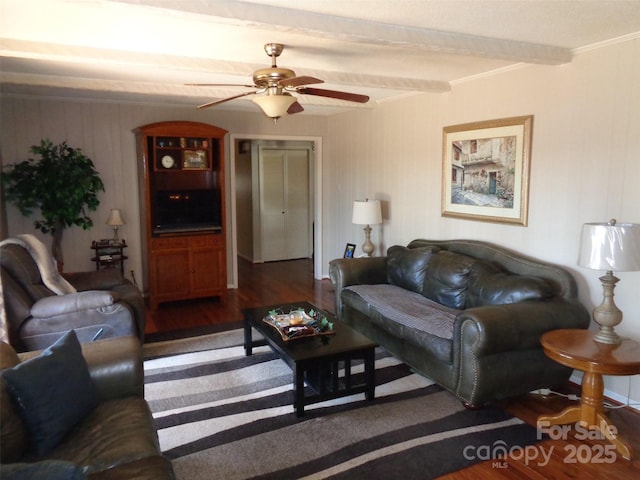 living room with beam ceiling, a ceiling fan, wood finished floors, and ornamental molding