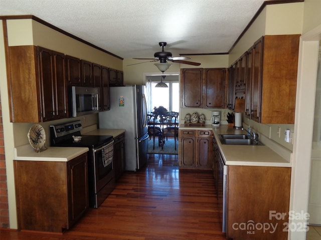 kitchen featuring crown molding, light countertops, appliances with stainless steel finishes, dark wood-type flooring, and a sink