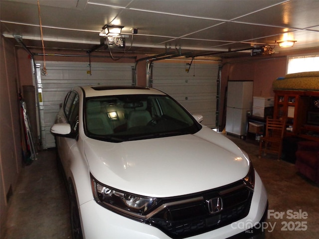 garage with freestanding refrigerator and a garage door opener