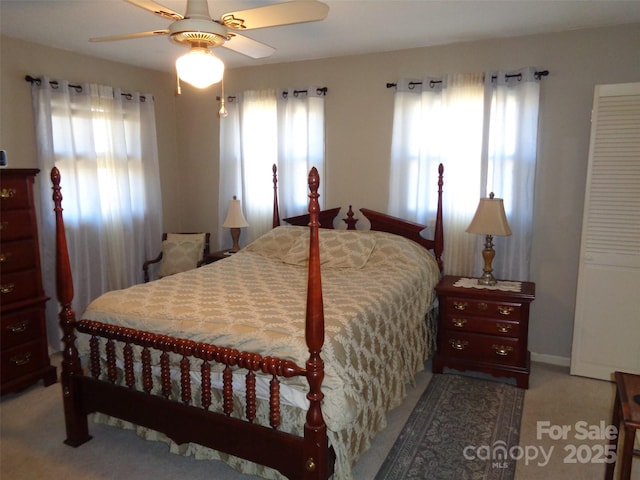 carpeted bedroom with ceiling fan and multiple windows