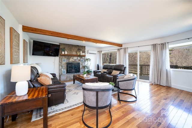 living room featuring a fireplace, wood finished floors, an AC wall unit, and beamed ceiling