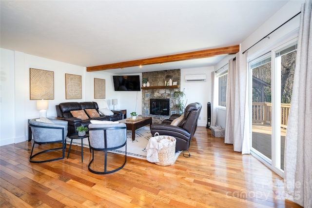 living area with baseboards, beamed ceiling, wood finished floors, an AC wall unit, and a fireplace