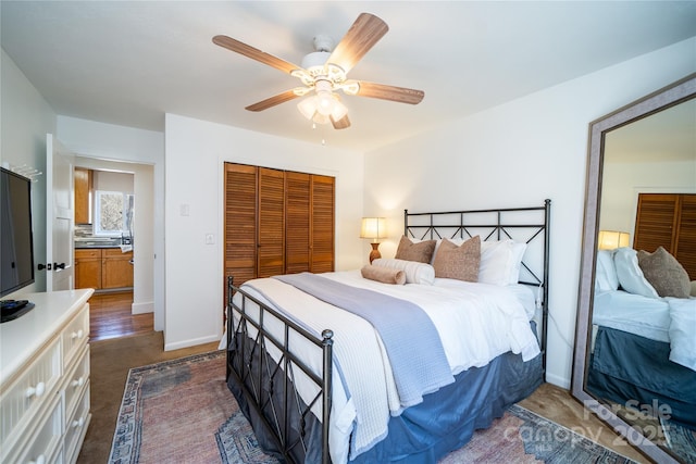 bedroom with a closet, ceiling fan, and baseboards