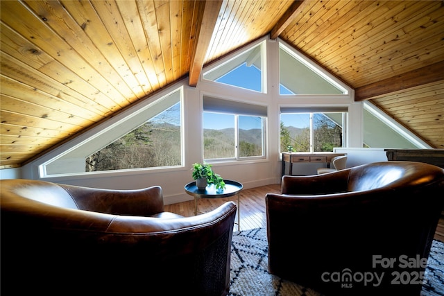 sitting room with wooden ceiling, a mountain view, lofted ceiling with beams, and wood finished floors