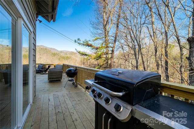 deck with a grill and a mountain view