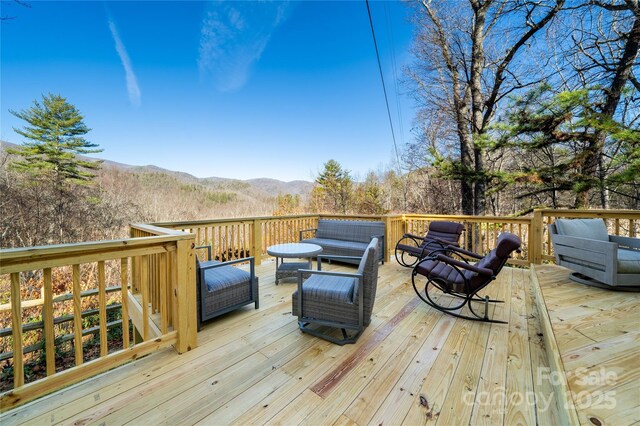 wooden deck featuring a mountain view and outdoor lounge area