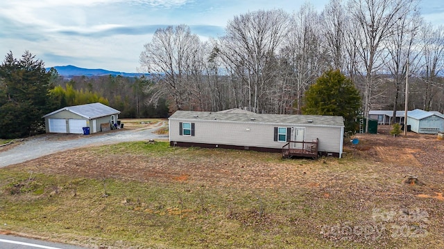 manufactured / mobile home featuring a garage, an outbuilding, and a mountain view