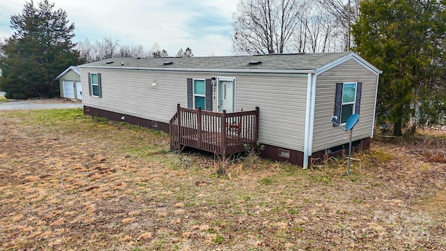 rear view of property featuring a lawn and an outdoor structure