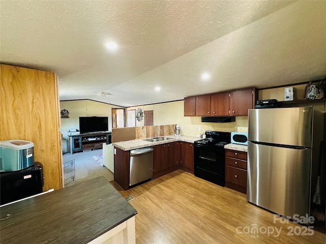 kitchen with light wood-style floors, lofted ceiling, appliances with stainless steel finishes, light countertops, and under cabinet range hood