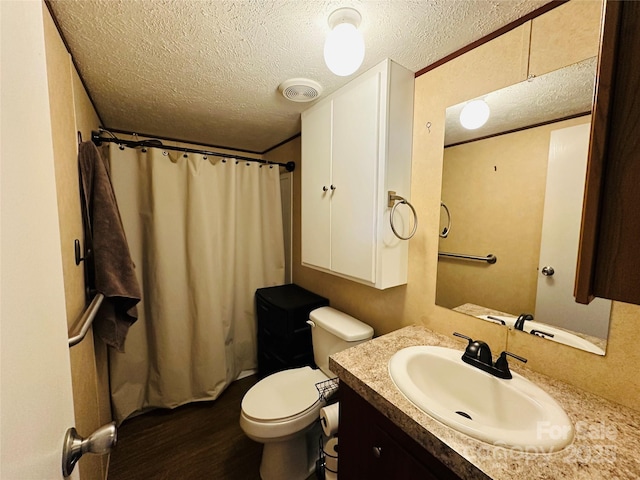 bathroom with a textured ceiling, toilet, vanity, and visible vents