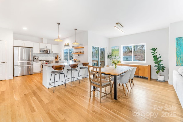 dining area with plenty of natural light and light wood finished floors