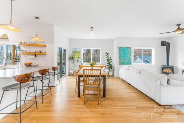 dining space featuring light wood-style flooring and a wood stove