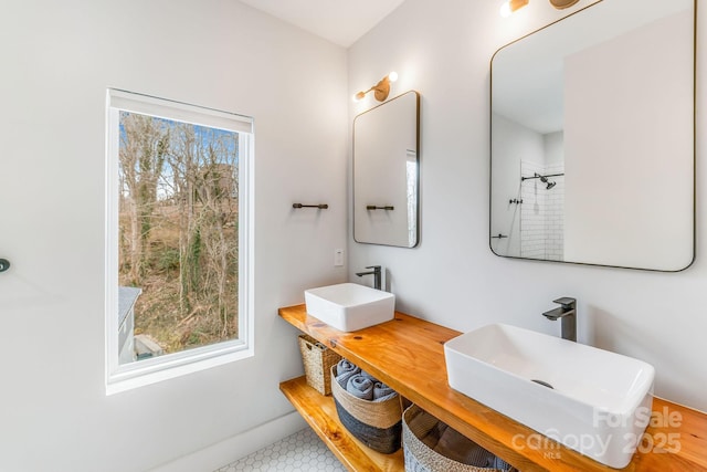 bathroom featuring a shower, baseboards, and a sink