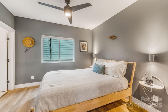 bedroom with ceiling fan, baseboards, and wood finished floors