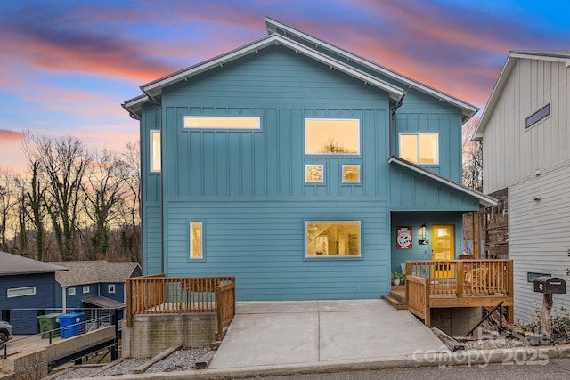 rear view of house featuring a patio area, board and batten siding, and a wooden deck