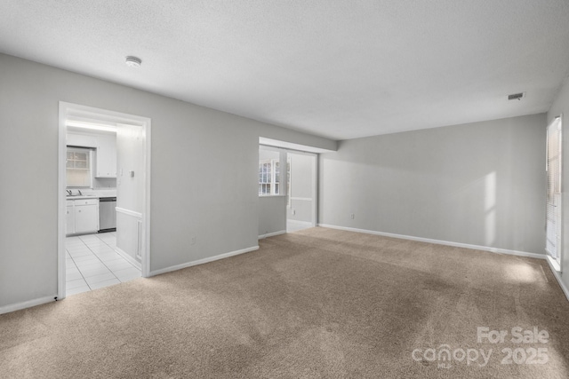 5948 Deveron Dr, Charlotte, NC 28211 - unfurnished living room with light colored carpet, visible vents, baseboards, and a textured ceiling
