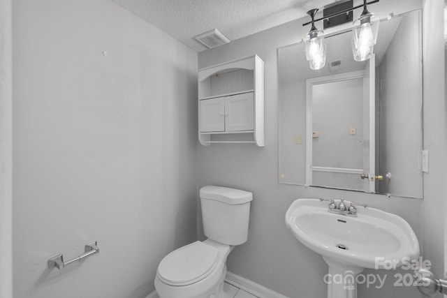5948 Deveron Dr, Charlotte, NC 28211 - half bathroom with toilet, a sink, a textured ceiling, baseboards, and visible vents