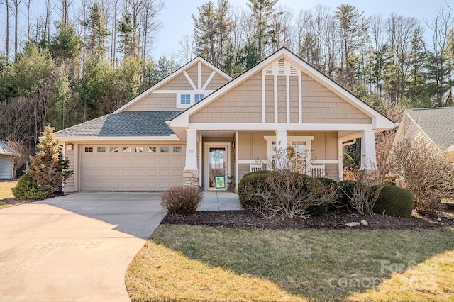 craftsman inspired home featuring a porch, an attached garage, concrete driveway, roof with shingles, and a front yard