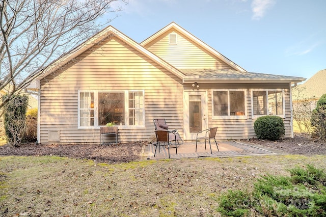 back of property featuring a patio and a lawn