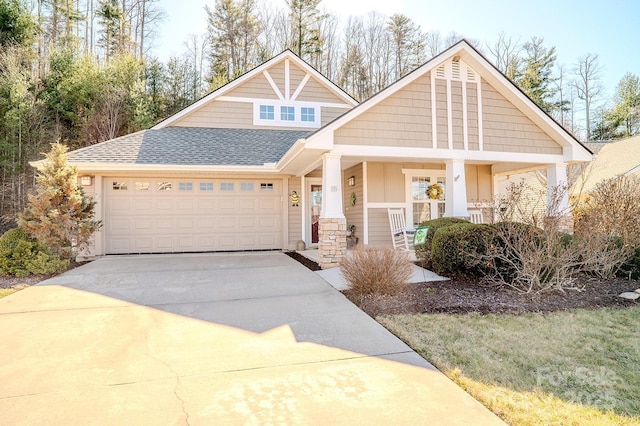 craftsman-style house with driveway, an attached garage, and roof with shingles