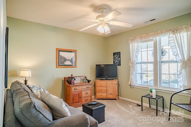 living area with light carpet, baseboards, visible vents, a ceiling fan, and a textured ceiling